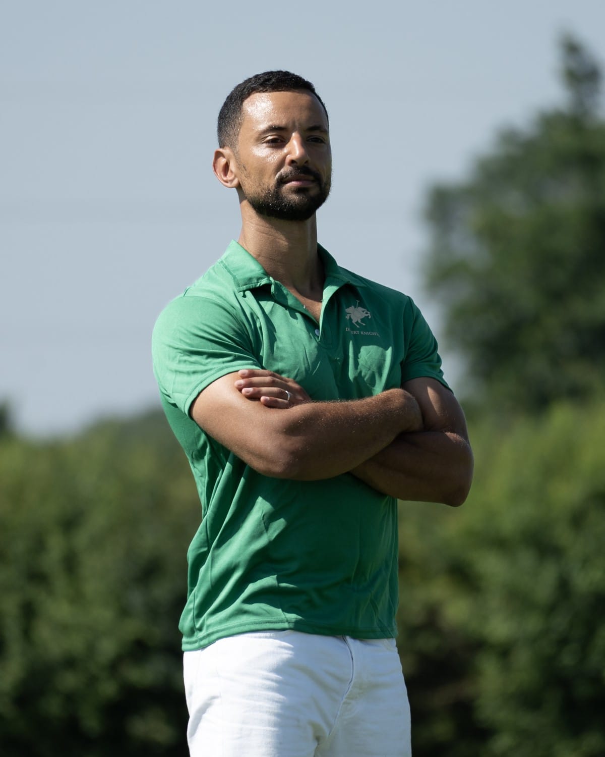 Saed El Alami standing with arms crossed in a green polo shirt on the polo field
